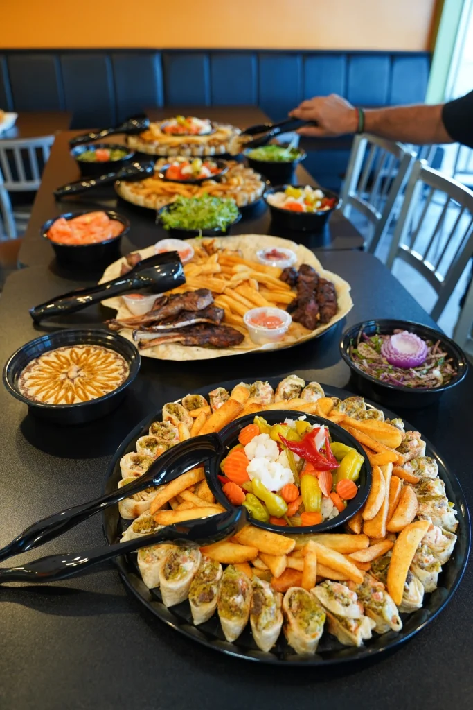 Abu Omar Halal catering spread with shawarma, sides, and salads