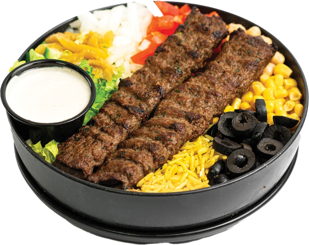 Two grilled beef kofta skewers over yellow rice, with a side salad
