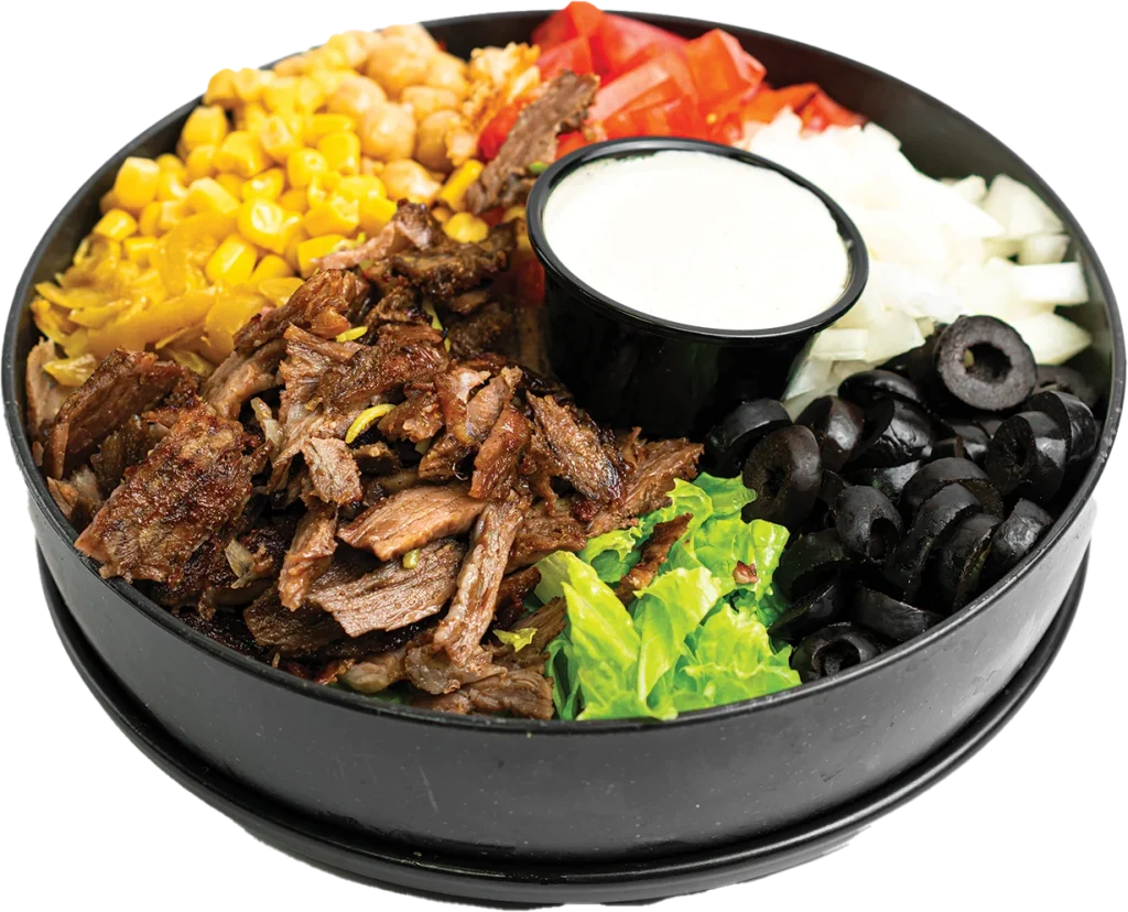 Shaved beef shawarma over a salad of greens, tomatoes, corn, chickpeas and olives