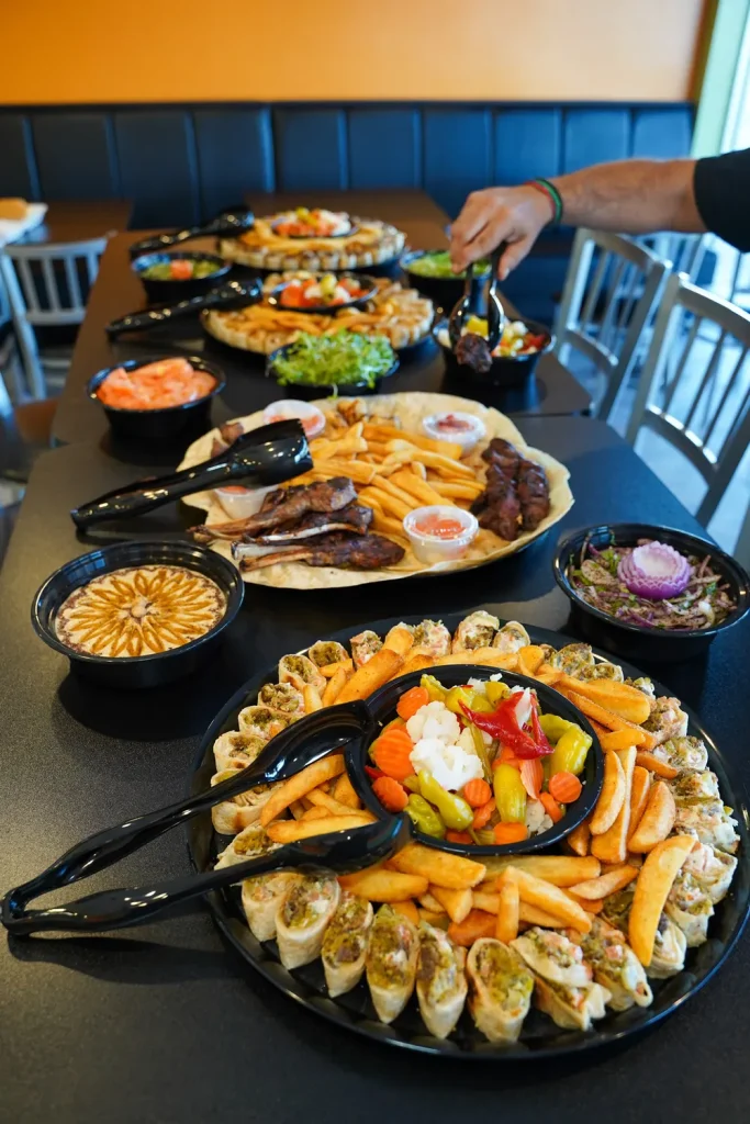 An Abu Omar Halal catering spread of wraps, bowls and sides laid out on a table