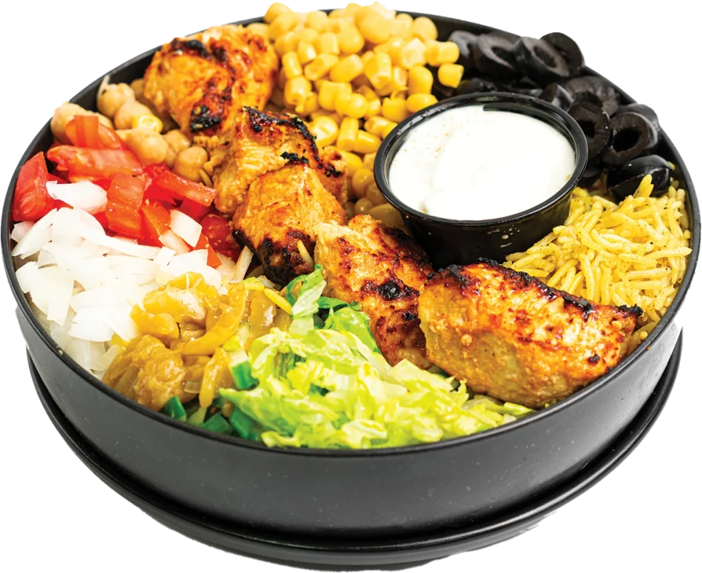 Grilled chicken kabob cubes over yellow rice, with a side salad