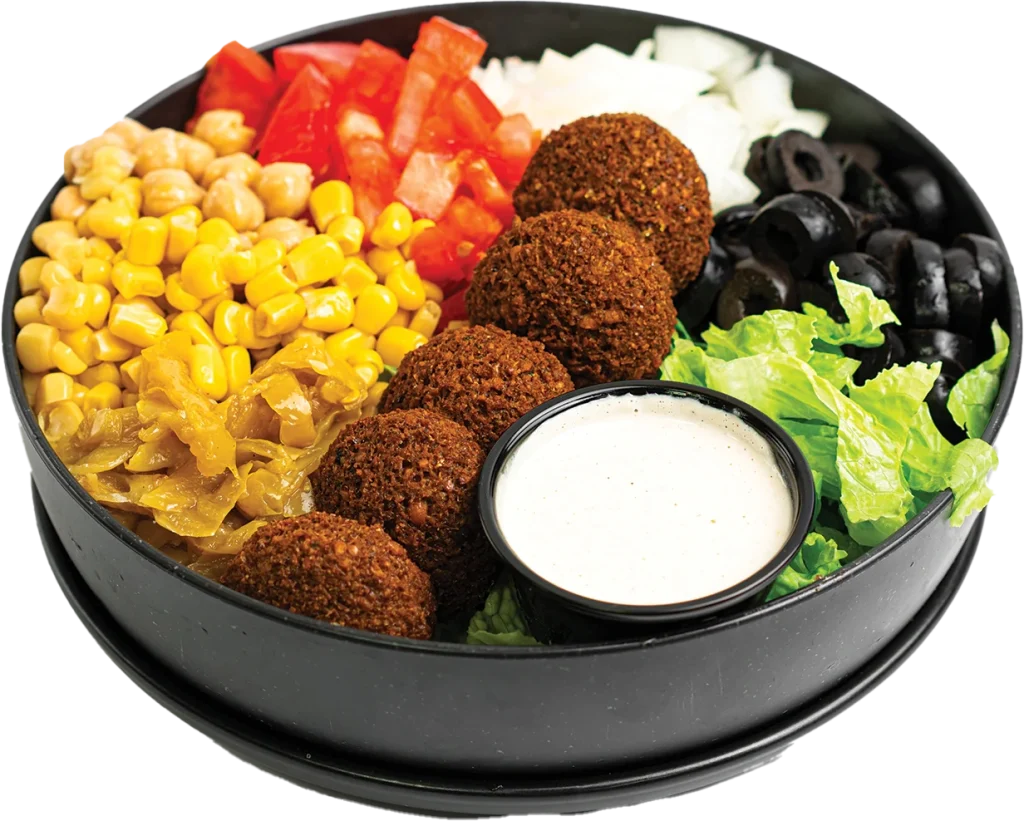 Five falafel balls over a salad of greens, tomatoes, corn, chickpeas and olives